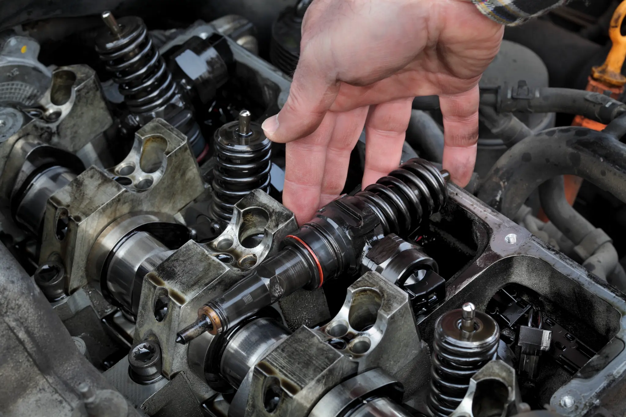 Technician removing a diesel fuel injector from an engine head