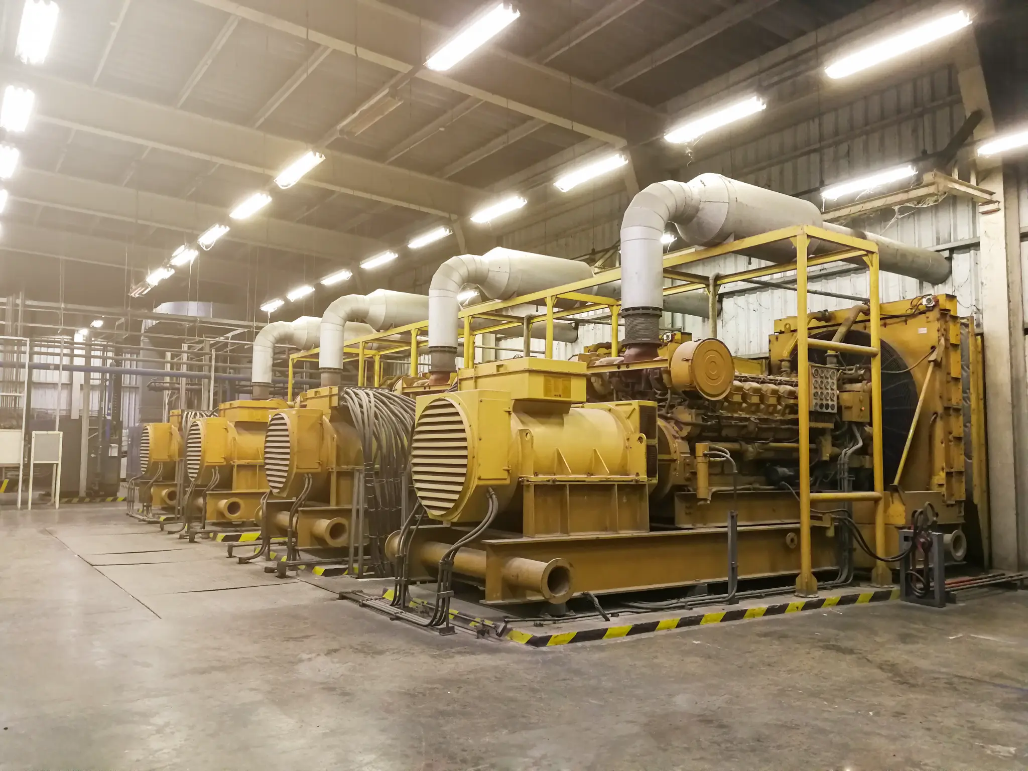 Row of large industrial diesel generators inside a facility
